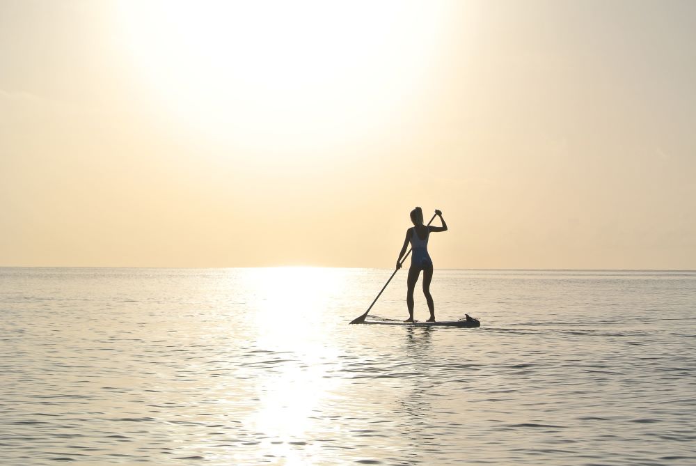 person paddle boarding on the ocean