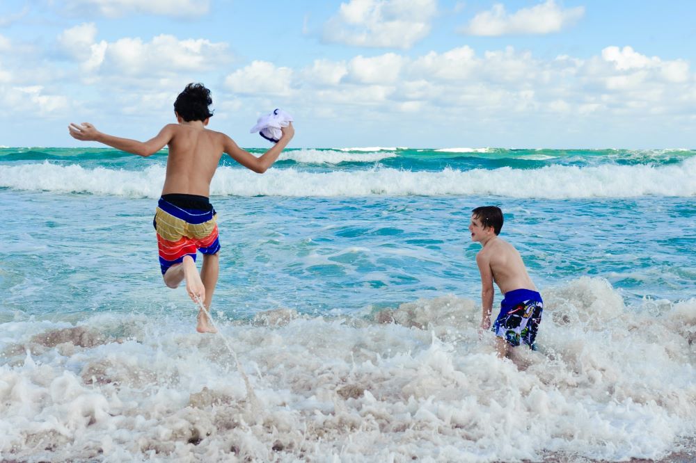 boys playing in ocean